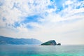 Seascape with desert island in blue heavens. Mediterranean landscape.