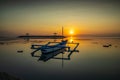 Seascape. Fisherman boat jukung. Sunrise landscape. Gazebos on an artificial island in the ocean. Water reflection. Sun on horizon Royalty Free Stock Photo