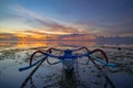 Seascape. Fisherman boat jukung. Traditional fishing boat at the beach during sunrise. Colorful sky. Amazing water reflection. Royalty Free Stock Photo