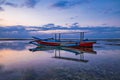 Seascape. Fisherman boat jukung. Traditional fishing boat at the beach during sunset. Cloudy sky. Amazing water reflection. Thomas Royalty Free Stock Photo