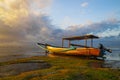 Seascape. Fisherman boat jukung. Traditional fishing boat at the beach during sunset. Cloudy sky. Water reflection. Thomas beach,