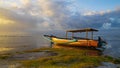 Seascape. Fisherman boat jukung. Traditional fishing boat at the beach during sunset. Cloudy sky. Water reflection. Thomas beach,