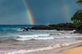 Seascape on Hawaii beach with a rainbow in the sky and ocean waves crashing to the beach Royalty Free Stock Photo