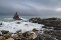 Seascape image of white waves rushing up the rocky beach