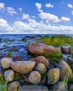 Seascape with large rocks on the shore and white clouds over blue sky, Royalty Free Stock Photo