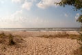 Seascape with large sand beach on the sun day. Sea waves roll of the sandy shore. The sun sky with clouds. Seashore Royalty Free Stock Photo