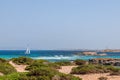 Seascape off the Ibiza coast with beautiful blue sea and a sailing yacht. In the distance the coast of Formentera island Royalty Free Stock Photo