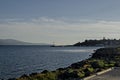 Seascape of pier with cross at end for fishing boat in the Black Sea and Balkan mountain with Cape Emine near ancient Nessebar Royalty Free Stock Photo