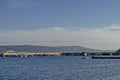 Seascape of pier with cross at end for fishing boat in the Black Sea and Balkan mountain with Cape Emine near ancient Nessebar Royalty Free Stock Photo