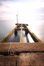 Seascape with pier and sunbeds and umbrellas and rocky shore shot with long explosure