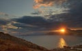 Seascape with red sun over the sea coast at sunset.