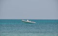 Seascape with ripple surface of blue sea water with white speedboat on anchor floating on calm waves