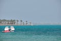 Seascape with ripple surface of blue sea water with white speedboat on anchor floating on calm waves