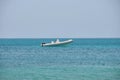 Seascape with ripple surface of blue sea water with white speedboat on anchor floating on calm waves