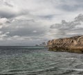 Seascape. rocky shore in the sea, wild beach and mountains, the rock goes into the sea view, wild landscape. clouds over the sea Royalty Free Stock Photo