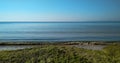 Seascape with sandy beach and green algae on the shore. Seascape with blue sea and sand. Photograph of the sea Royalty Free Stock Photo