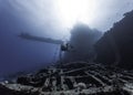 Seascape of a scuba diver swimming in the distance over a very large ship wreck Royalty Free Stock Photo