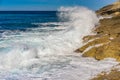 Seascape with sea water spindrift breaking on rocky coastline Royalty Free Stock Photo