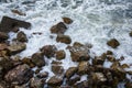 Seascape, seafoam of storm on wild rocky seashore