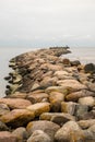 Seascape Sentinel: Stone Jetty Pathway to the Overlooking Beacon of the Endless Sea Royalty Free Stock Photo