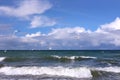 Seascape with storm sea waves with foam under heavy cumulonimbus on the sky till horizon and flying seagulls Royalty Free Stock Photo