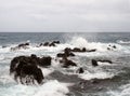 Seascape with stormy dramatic waves breaking over coastal rocks with white surf Royalty Free Stock Photo