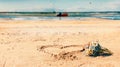 Seascape Summer beach on sand bouquet wild flowers and heart sign blue sea water on horizon romantic background