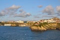 Seascape: sunset lit town on cliffs, blue skies