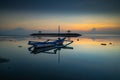 Seascape. Traditional fisherman boat jukung. Sunrise landscape. Gazebos on an artificial island in the ocean.  Water reflection. Royalty Free Stock Photo