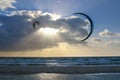 Seascape with two kites, sun over the sea in blue colours, the rays break through the clouds Royalty Free Stock Photo