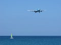 Seascape: vibrant sailboat and airplane over sea