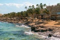 View of a wooden pier on the tropical seashore with blue sky and sea.