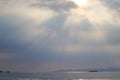 Seascape view with horizon over the water on a cloudy day with sun rays through a dramatic grey sky Royalty Free Stock Photo