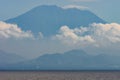 Seascape. View from the sea of the coast tropical island in a strong haze. Big mountain covers the horizon. Soft focus. Natura