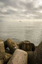 Seascape with wave-breaks in foreground, cargo ship in the horizon