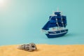 A seashell on the sand against a sailboat on a blue background