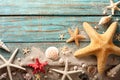 Seashell, starfish and beach sand on blue wooden background. Summer holiday concept. Top view Royalty Free Stock Photo