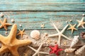 Seashell, starfish and beach sand on blue wooden background. Summer holiday concept. Top view Royalty Free Stock Photo