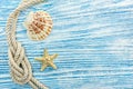 Seashell, starfish, marine rope on blue wooden scratched boards