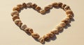 Seashells arranged in a heart shape on a beige surface. The shells vary in size and Royalty Free Stock Photo