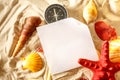 Seashells, compass and paper on sand Royalty Free Stock Photo