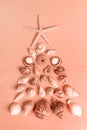 Seashells and starfish laid out as alternative Xmas tree in Calming Coral color. Vertical shot Royalty Free Stock Photo