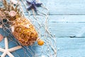 Seashells, starfish and ripe pineapple in fishing net on blue wooden boards, tropical summer vacation concept abstract Royalty Free Stock Photo