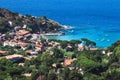 Seashore coastline with beach and little village in the Island of Elba in Italy. Many people on the beach sunbathing. Blue sea Royalty Free Stock Photo