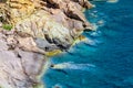 Seashore coastline with cliff and rocks on a mountain slope. Blue sea of the Island of Elba in Italy in the Tuscany region.