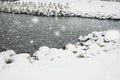 Seashore with large stones and buoys against the backdrop of falling snow Royalty Free Stock Photo