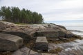 Seashore with large stones and pine tree on the stones Royalty Free Stock Photo
