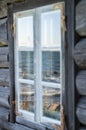 Seashore reflection in rustic cottage window of old wooden piscatorial house Royalty Free Stock Photo