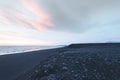 seashore with rocks and cloudy sky at sunset, solheimasandur Royalty Free Stock Photo