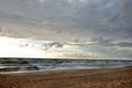 Seashore sky blue tones dark heavy clouds and sea waves sand beach beautiful nature sunset Royalty Free Stock Photo